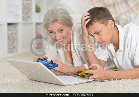 To use this stock image in your creative project, please select the size you need over to the right and click the "Add to Cart" button.
Your downloaded image will come with the Cutcaster watermark removed so don’t worry about the watermark you see on this page. portrait of grandmother and grandson playing computer game with stock photo, portrait of grandmother and grandson playing computer game with laptop by Ruslan Huzau