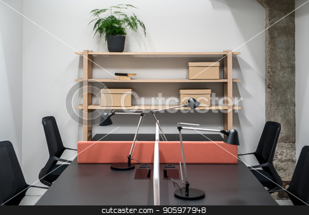 To use this stock image in your creative project, please select the size you need over to the right and click the "Add to Cart" button.
Your downloaded image will come with the Cutcaster watermark removed so don’t worry about the watermark you see on this page. Stylish office in loft style with gray walls stock photo, Illuminated interior in an office with gray walls and a concrete column. There are wooden shelves with cardboard boxes and green plant and books, black table with a peach partition and lamps, chairs. by bezikus