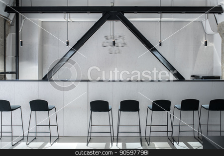 To use this stock image in your creative project, please select the size you need over to the right and click the "Add to Cart" button.
Your downloaded image will come with the Cutcaster watermark removed so don’t worry about the watermark you see on this page. Stylish interior in loft style with gray walls stock photo, Nice bar with a rack and black wooden partitions in a luminous interior in a loft style with gray walls and concrete columns. There are several dark chairs, hanging lamps. Horizontal. by bezikus