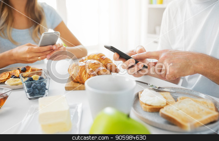 To use this stock image in your creative project, please select the size you need over to the right and click the "Add to Cart" button.
Your downloaded image will come with the Cutcaster watermark removed so don’t worry about the watermark you see on this page. close up of couple with smartphones at breakfast stock photo, food and technology concept - close up of couple with smartphones having breakfast at home by Syda Productions