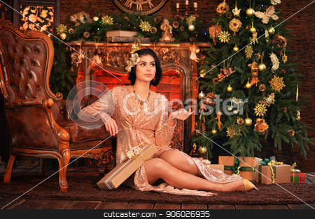 To use this stock image in your creative project, please select the size you need over to the right and click the "Add to Cart" button.
Your downloaded image will come with the Cutcaster watermark removed so don’t worry about the watermark you see on this page. Portrait of beautiful young woman in golden dress posing stock photo, Portrait of beautiful young woman in golden dress posing in room decorated to Christmas holiday by Ruslan Huzau