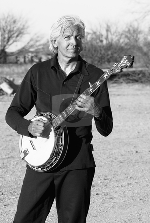 To use this stock image in your creative project, please select the size you need over to the right and click the "Add to Cart" button.
Your downloaded image will come with the Cutcaster watermark removed so don’t worry about the watermark you see on this page. Banjo Player stock photo, Banjo player with his instrument in a rural setting by Scott Griessel