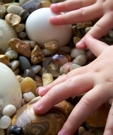To use this stock image in your creative project, please select the size you need over to the right and click the "Add to Cart" button.
Your downloaded image will come with the Cutcaster watermark removed so don’t worry about the watermark you see on this page. Child's Hands with Pebbles and Stone Eggs, Vertical stock photo, by Jill Oliver