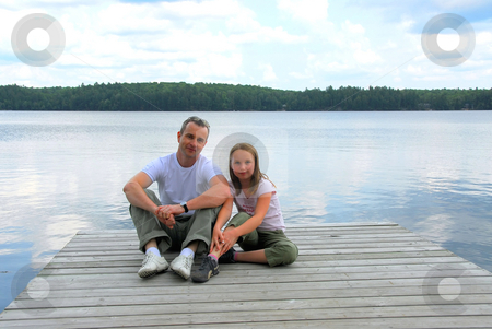 To use this stock image in your creative project, please select the size you need over to the right and click the "Add to Cart" button.
Your downloaded image will come with the Cutcaster watermark removed so don’t worry about the watermark you see on this page. Father child lake stock photo, Father and child sitting on a wooden pier on a lake by Elena Elisseeva