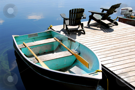 To use this stock image in your creative project, please select the size you need over to the right and click the "Add to Cart" button.
Your downloaded image will come with the Cutcaster watermark removed so don’t worry about the watermark you see on this page. Lake chairs stock photo, Two wooden adirondack chairs on a boat dock on a beautiful still lake with sky reflection by Elena Elisseeva