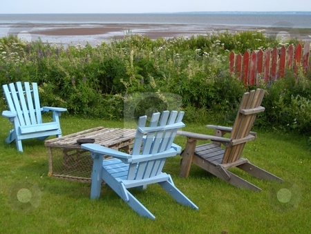 To use this stock image in your creative project, please select the size you need over to the right and click the "Add to Cart" button.
Your downloaded image will come with the Cutcaster watermark removed so don’t worry about the watermark you see on this page. Ocean View stock photo, Three adriondack chairs with a lobster trap for a coffee table in a yard overlooking the ocean. by Jessica Tooley