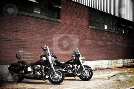 To use this stock image in your creative project, please select the size you need over to the right and click the "Add to Cart" button.
Your downloaded image will come with the Cutcaster watermark removed so don’t worry about the watermark you see on this page. Dual Harleys stock photo, Two Harley-Davidson motorcycles parked outside a warehouse. by Nathan Smith