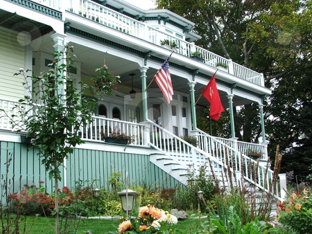 To use this stock image in your creative project, please select the size you need over to the right and click the "Add to Cart" button.
Your downloaded image will come with the Cutcaster watermark removed so don’t worry about the watermark you see on this page. Comfortable vintage house stock photo, Colorful decor with wonderful landscaping makes this interesting old wood frame home with expansive front porch in Boothbay Harbor, Maine stand out from the neighbors (photo 10/08/07). by Dennis Thomsen
