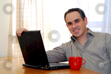 To use this stock image in your creative project, please select the size you need over to the right and click the "Add to Cart" button.
Your downloaded image will come with the Cutcaster watermark removed so don’t worry about the watermark you see on this page. Man with laptop stock photo, Man sitting at a desk and looking into his computer by Elena Elisseeva
