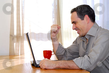 To use this stock image in your creative project, please select the size you need over to the right and click the "Add to Cart" button.
Your downloaded image will come with the Cutcaster watermark removed so don’t worry about the watermark you see on this page. Man with laptop stock photo, Man sitting at a desk and looking into his computer showing happiness and excitement by Elena Elisseeva
