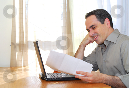 To use this stock image in your creative project, please select the size you need over to the right and click the "Add to Cart" button.
Your downloaded image will come with the Cutcaster watermark removed so don’t worry about the watermark you see on this page. Man with laptop stock photo, Man sitting at his desk with a laptop and papers looking happy by Elena Elisseeva