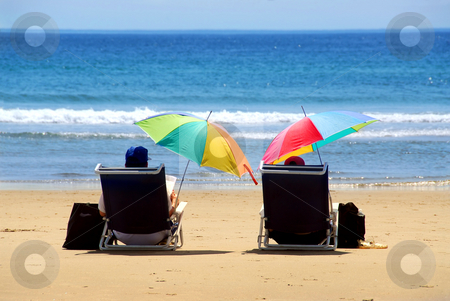 To use this stock image in your creative project, please select the size you need over to the right and click the "Add to Cart" button.
Your downloaded image will come with the Cutcaster watermark removed so don’t worry about the watermark you see on this page. Couple beach stock photo, A couple relaxing on a beach under colorful umbrellas by Elena Elisseeva