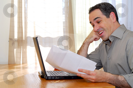 To use this stock image in your creative project, please select the size you need over to the right and click the "Add to Cart" button.
Your downloaded image will come with the Cutcaster watermark removed so don’t worry about the watermark you see on this page. Man with laptop stock photo, Man sitting at a desk looking at bills and smiling by Elena Elisseeva