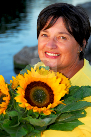 To use this stock image in your creative project, please select the size you need over to the right and click the "Add to Cart" button.
Your downloaded image will come with the Cutcaster watermark removed so don’t worry about the watermark you see on this page. Woman sunflowers stock photo, Portrait of a mature woman with sunflowers by Elena Elisseeva