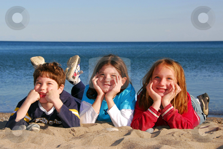 To use this stock image in your creative project, please select the size you need over to the right and click the "Add to Cart" button.
Your downloaded image will come with the Cutcaster watermark removed so don’t worry about the watermark you see on this page. Three children on a beach stock photo, Three children lying on a beach laughing by Elena Elisseeva