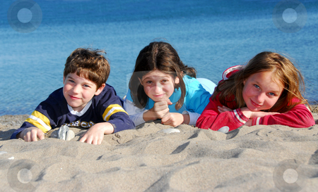 To use this stock image in your creative project, please select the size you need over to the right and click the "Add to Cart" button.
Your downloaded image will come with the Cutcaster watermark removed so don’t worry about the watermark you see on this page. Children on a beach stock photo, Three kinds lying on a beach by Elena Elisseeva