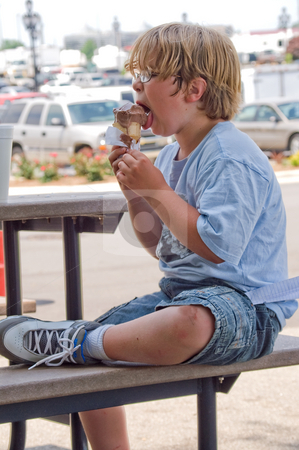 To use this stock image in your creative project, please select the size you need over to the right and click the "Add to Cart" button.
Your downloaded image will come with the Cutcaster watermark removed so don’t worry about the watermark you see on this page. Boy Eating Ice Cream stock photo, A young boy eating an ice cream cone. by Robert Byron