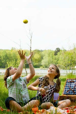 To use this stock image in your creative project, please select the size you need over to the right and click the "Add to Cart" button.
Your downloaded image will come with the Cutcaster watermark removed so don’t worry about the watermark you see on this page. Throwing an apple stock photo, Two children enjoying a picnic in the summer by Frenk and Danielle Kaufmann