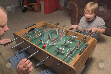 To use this stock image in your creative project, please select the size you need over to the right and click the "Add to Cart" button.
Your downloaded image will come with the Cutcaster watermark removed so don’t worry about the watermark you see on this page. Foosball Players stock photo, A man and a boy playing a game of foosball. by Robert Byron