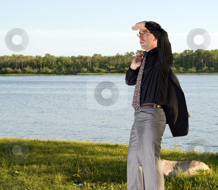 To use this stock image in your creative project, please select the size you need over to the right and click the "Add to Cart" button.
Your downloaded image will come with the Cutcaster watermark removed so don’t worry about the watermark you see on this page. Lookout stock photo, A young businessman standing by a small lake, holding his hand over his eyes to see better by Richard Nelson