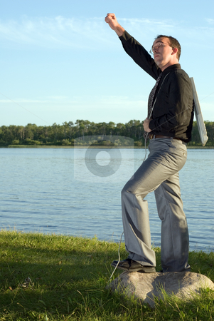 To use this stock image in your creative project, please select the size you need over to the right and click the "Add to Cart" button.
Your downloaded image will come with the Cutcaster watermark removed so don’t worry about the watermark you see on this page. Success stock photo, A businessman standing with his fist in the air holding a keyboard by Richard Nelson