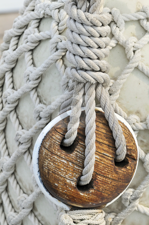 To use this stock image in your creative project, please select the size you need over to the right and click the "Add to Cart" button.
Your downloaded image will come with the Cutcaster watermark removed so don’t worry about the watermark you see on this page. Old wooden block stock photo, Close-up of an old block on a sailboat with a bumper covered by a rope net in background by Massimiliano Leban