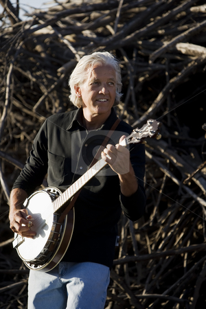 To use this stock image in your creative project, please select the size you need over to the right and click the "Add to Cart" button.
Your downloaded image will come with the Cutcaster watermark removed so don’t worry about the watermark you see on this page. Banjo Player Outdoors stock photo, Banjo Player in Front of a Big Pile of Wood by Scott Griessel