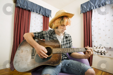 To use this stock image in your creative project, please select the size you need over to the right and click the "Add to Cart" button.
Your downloaded image will come with the Cutcaster watermark removed so don’t worry about the watermark you see on this page. Young Guitar Player stock photo, Young musician with an old guitar in an empty room by Scott Griessel