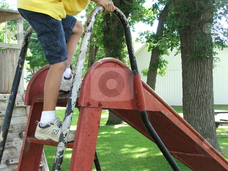 To use this stock image in your creative project, please select the size you need over to the right and click the "Add to Cart" button.
Your downloaded image will come with the Cutcaster watermark removed so don’t worry about the watermark you see on this page. Old Playground Slide stock photo, A young boy prepares to slide down an old, well-used, metal, slide displaying a history of multiple coats of paint in a small park playground in Chester, Iowa. by Dennis Thomsen