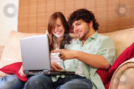 To use this stock image in your creative project, please select the size you need over to the right and click the "Add to Cart" button.
Your downloaded image will come with the Cutcaster watermark removed so don’t worry about the watermark you see on this page. Young couple on computer stock photo, Young couple relaxing on a couch, playing with a laptop computer, laughing and pointing. by Nicolaas Traut