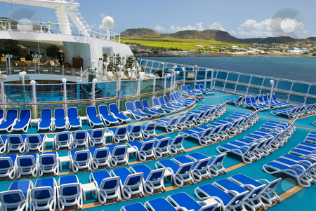 To use this stock image in your creative project, please select the size you need over to the right and click the "Add to Cart" button.
Your downloaded image will come with the Cutcaster watermark removed so don’t worry about the watermark you see on this page. Empty Cruise Ship Deck in the Islands stock photo, A cruise ship deck is empty during a visit to a tropical island by Jeff Clow