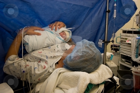 To use this stock image in your creative project, please select the size you need over to the right and click the "Add to Cart" button.
Your downloaded image will come with the Cutcaster watermark removed so don’t worry about the watermark you see on this page. Mother and baby stock photo, Mother with her baby during c-section. by Mariusz Jurgielewicz