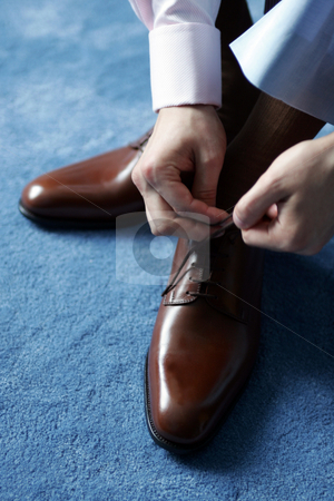 To use this stock image in your creative project, please select the size you need over to the right and click the "Add to Cart" button.
Your downloaded image will come with the Cutcaster watermark removed so don’t worry about the watermark you see on this page. Businessman dressing for work stock photo, Businessman tying his shoes as he gets dressed for work. by Martin Crowdy