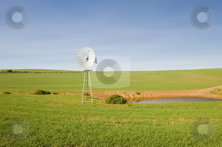 To use this stock image in your creative project, please select the size you need over to the right and click the "Add to Cart" button.
Your downloaded image will come with the Cutcaster watermark removed so don’t worry about the watermark you see on this page. Traditional windmill in a green pasture stock photo, A traditional windmill turning in the wind and pumping water out of the ground into a catchment dam to the right. by Nicolaas Traut