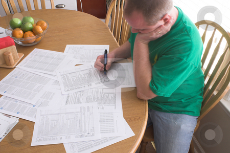 To use this stock image in your creative project, please select the size you need over to the right and click the "Add to Cart" button.
Your downloaded image will come with the Cutcaster watermark removed so don’t worry about the watermark you see on this page. Man Doing Taxes stock photo, A man doing his taxes in the kitchen. by Robert Byron
