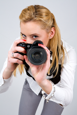 To use this stock image in your creative project, please select the size you need over to the right and click the "Add to Cart" button.
Your downloaded image will come with the Cutcaster watermark removed so don’t worry about the watermark you see on this page. Woman motioning to Say me Cheese, please stock photo, Young blond woman holding camera in studio by Vitaly Sokolovskiy