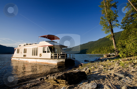 To use this stock image in your creative project, please select the size you need over to the right and click the "Add to Cart" button.
Your downloaded image will come with the Cutcaster watermark removed so don’t worry about the watermark you see on this page. Luxury House Boat stock photo, A luxury house boat beached on a beautiful lake by Tyler Olson