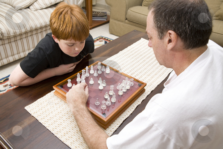To use this stock image in your creative project, please select the size you need over to the right and click the "Add to Cart" button.
Your downloaded image will come with the Cutcaster watermark removed so don’t worry about the watermark you see on this page. Father and son playing chess indoors stock photo, A father and 10 year old son playing chess indoors by Magdalena Ascough