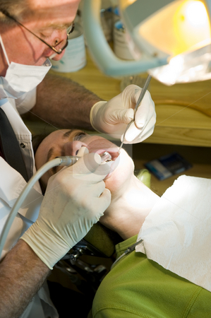 To use this stock image in your creative project, please select the size you need over to the right and click the "Add to Cart" button.
Your downloaded image will come with the Cutcaster watermark removed so don’t worry about the watermark you see on this page. Dentist working stock photo, A mature dentist working on a lady patient, using a drill to even off some edges of a newly fitted crown. by Nicolaas Traut