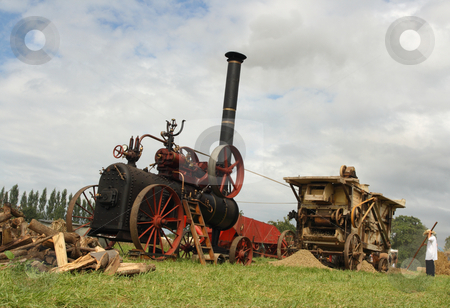 To use this stock image in your creative project, please select the size you need over to the right and click the "Add to Cart" button.
Your downloaded image will come with the Cutcaster watermark removed so don’t worry about the watermark you see on this page. Vintage harvest scene stock photo, Vintage traction steam engine and threshing machine working in a field at the wheat fest by Tilo