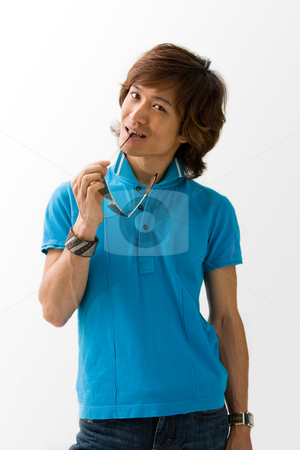 To use this stock image in your creative project, please select the size you need over to the right and click the "Add to Cart" button.
Your downloaded image will come with the Cutcaster watermark removed so don’t worry about the watermark you see on this page. Happy Asian guy with sunglasses stock photo, Happy Asian guy in blue t-shirt holding sunglasses and biting on it, isolated by Paul Hakimata