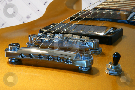 To use this stock image in your creative project, please select the size you need over to the right and click the "Add to Cart" button.
Your downloaded image will come with the Cutcaster watermark removed so don’t worry about the watermark you see on this page. Gold Guitar stock photo, A closeup of a gold guitar on a music background by Sam Sapp