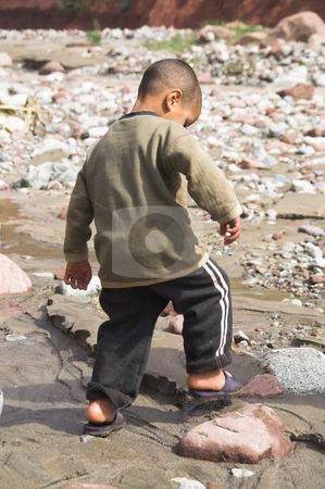 To use this stock image in your creative project, please select the size you need over to the right and click the "Add to Cart" button.
Your downloaded image will come with the Cutcaster watermark removed so don’t worry about the watermark you see on this page. Boy playing on the riverbank stock photo, Small boy playing on the riverbank in Morocco by stomping his foot in the mud by Szilard Kun