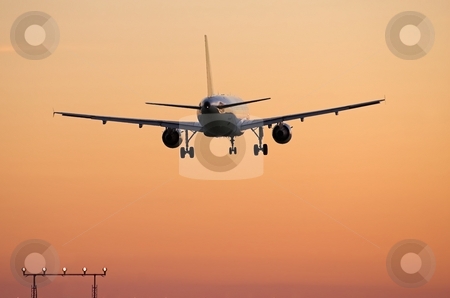 To use this stock image in your creative project, please select the size you need over to the right and click the "Add to Cart" button.
Your downloaded image will come with the Cutcaster watermark removed so don’t worry about the watermark you see on this page. Airliner landing at sunset stock photo, Rear view of jet airplane over the approach lights at major airport by Pierre Landry