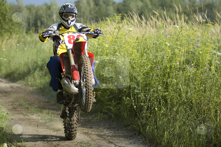 To use this stock image in your creative project, please select the size you need over to the right and click the "Add to Cart" button.
Your downloaded image will come with the Cutcaster watermark removed so don’t worry about the watermark you see on this page. Motocross rider stock photo, A motocross rider making wheelies on his bike by Vlad Podkhlebnik