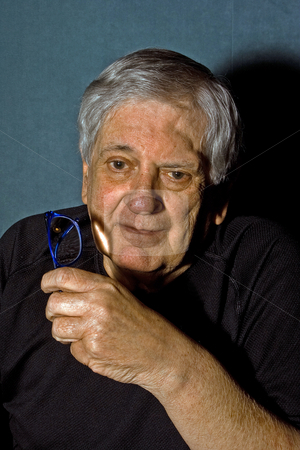 To use this stock image in your creative project, please select the size you need over to the right and click the "Add to Cart" button.
Your downloaded image will come with the Cutcaster watermark removed so don’t worry about the watermark you see on this page. Senior man with glasses stock photo, Dramatic portrait of a senior man with a pair of blue glasses in his hand wearing a black shirt isolated on gray/blue by Paul Hakimata