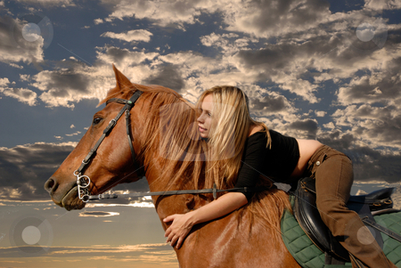 To use this stock image in your creative project, please select the size you need over to the right and click the "Add to Cart" button.
Your downloaded image will come with the Cutcaster watermark removed so don’t worry about the watermark you see on this page. Riding girl stock photo, Young riding girl in a storm sky with her brown stallion by Bonzami Emmanuelle