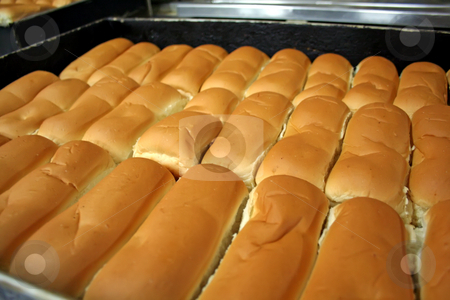 To use this stock image in your creative project, please select the size you need over to the right and click the "Add to Cart" button.
Your downloaded image will come with the Cutcaster watermark removed so don’t worry about the watermark you see on this page. Bakery buns stock photo, Rows of bread loaves in racks in a bakery by Kheng Guan Toh