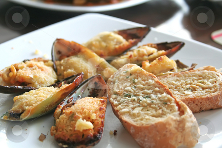 To use this stock image in your creative project, please select the size you need over to the right and click the "Add to Cart" button.
Your downloaded image will come with the Cutcaster watermark removed so don’t worry about the watermark you see on this page. Baked mussels stock photo, Breaded baked mussels in shell white plate restaurant setting by Kheng Guan Toh