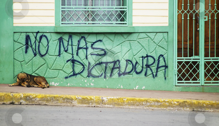 To use this stock image in your creative project, please select the size you need over to the right and click the "Add to Cart" button.
Your downloaded image will come with the Cutcaster watermark removed so don’t worry about the watermark you see on this page. Anti government graffiti in Nicaragua stock photo, Dog sleeps in front of anti government grafitti in Granada Nicaragua by Scott Griessel